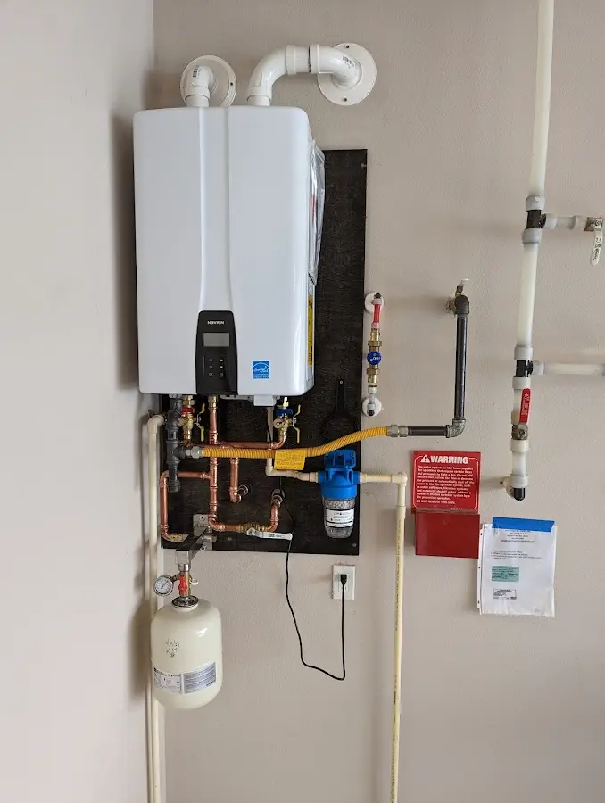 Professional plumber installing copper piping in a Howland Center home